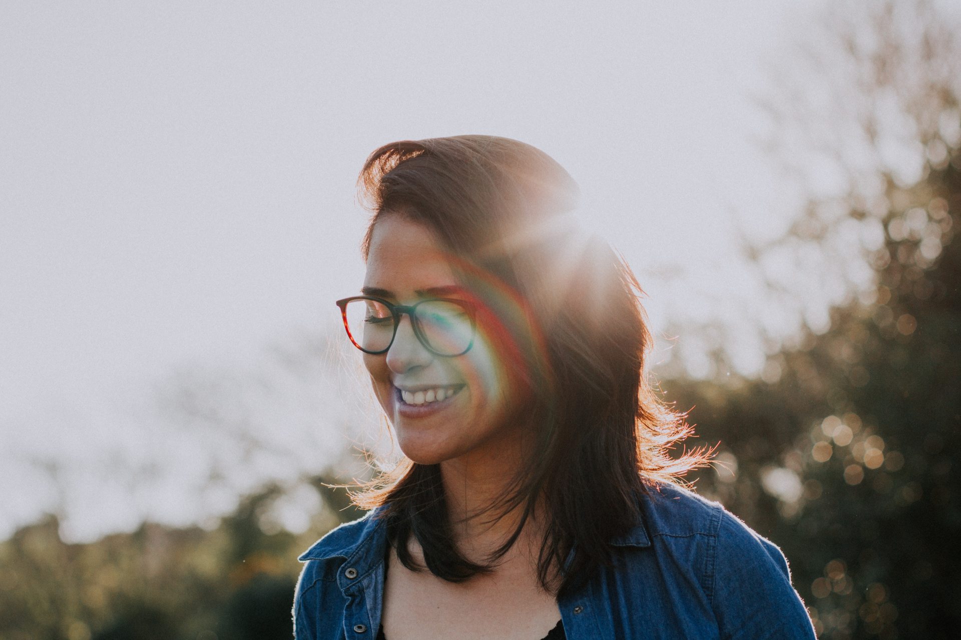 Person is smiling and sun is shining behind of her.